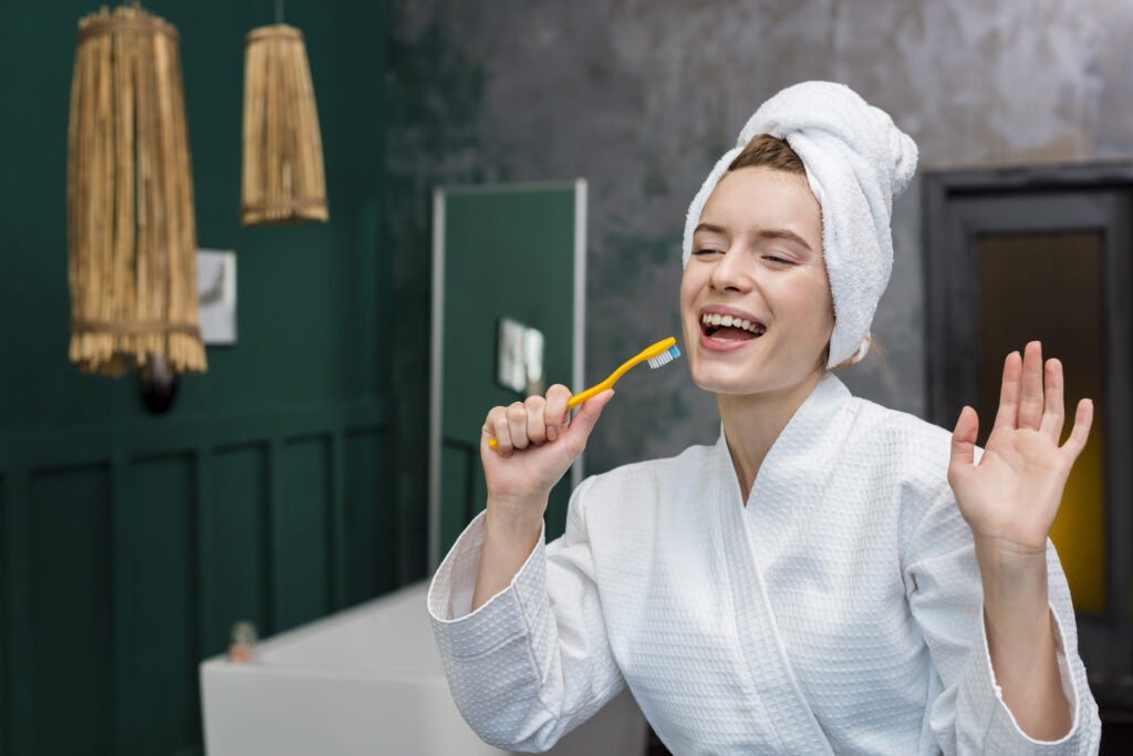 woman-bathrobe-playing-around-with-toothbrush