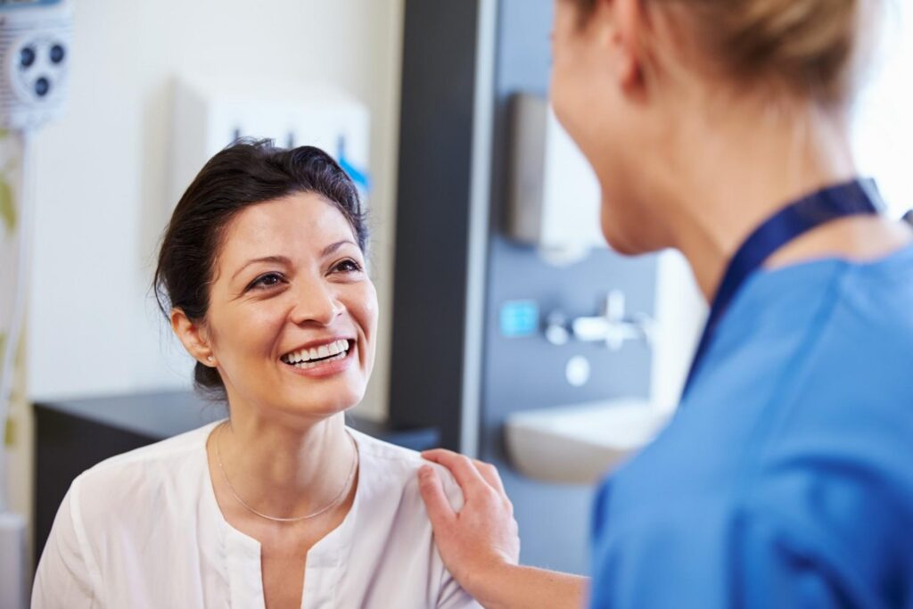 Smiling dental patient speaking with a dental professional